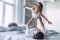 Un père et sa fille s'amusent joyeusement sur un lit dans une chambre lumineuse et chaleureuse