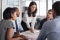 Une équipe professionnelle diversifiée travaillant ensemble dans un bureau moderne, avec une femme qui anime la discussion