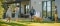 Une famille profitant de son jardin devant une maison moderne équipée d'une pompe à chaleur air-eau Carrier fixée au mur.